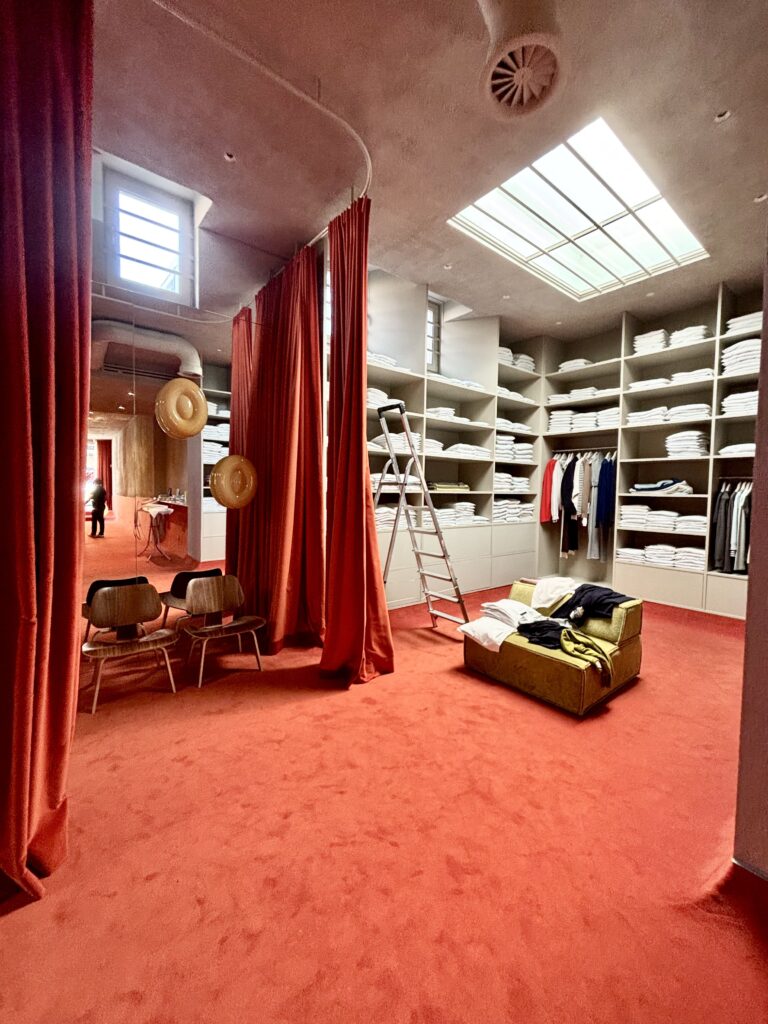 Une marque qui refuse les cycles de la mode
Extreme Cashmere ne suit pas les saisons traditionnelles. Pas de collection printemps-été, pas de collection automne-hiver. La marque produit des pièces en cachemire intemporelles, disponibles en continu, pensées pour durer. Et son espace de vente est à l'image de cette philosophie.
L'absence de prix n'est pas un oubli mais un choix. On entre ici pour toucher, pour ressentir, pour prendre le temps d'une conversation avec le personnel de vente. Le contact client est travaillé, personnalisé, presque sur-mesure. On est loin du retail transactionnel. On est dans le retail de relation.